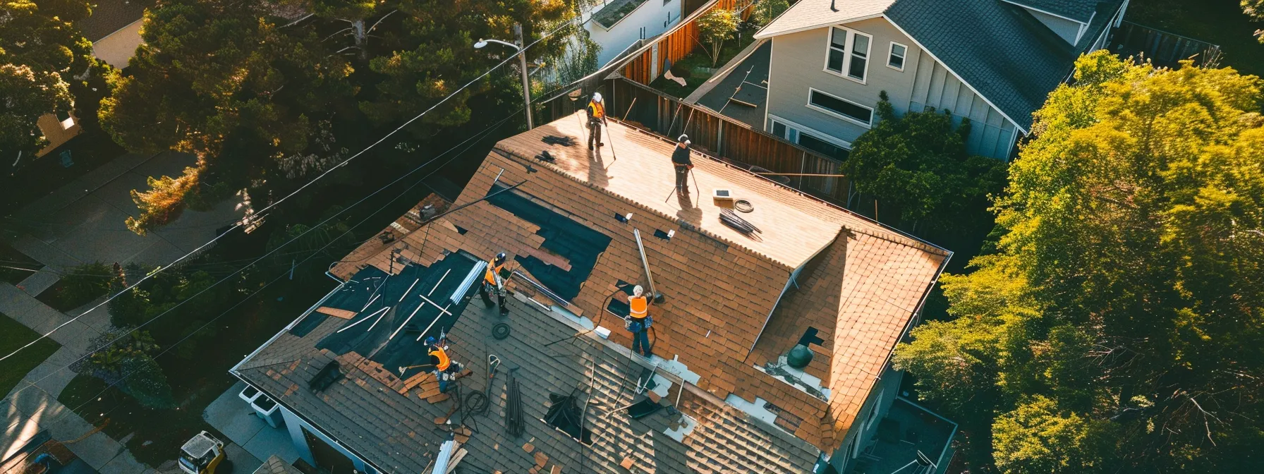 a group of roofers working on a house in a residential neighborhood.